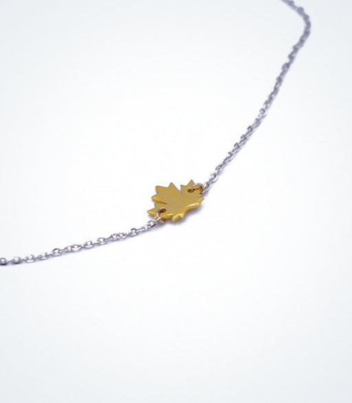 Yellow gold Maple Leaf motif with a white gold chain bracelet